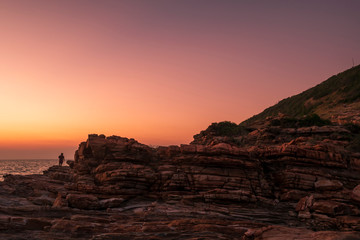 silhouette of a man standing to watch the light of the sunset