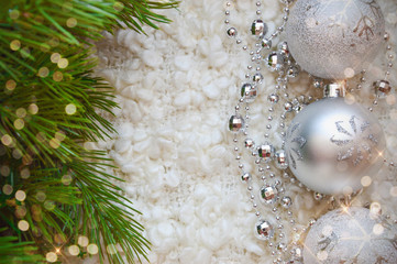 Decor for a happy Christmas and New year. Silver color. Christmas balls and beads on a white cozy blanket. happy winter holidays. Background for congratulations. Grey balls for Christmas tree decorati