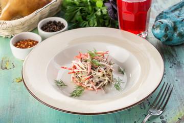 Beef salad with fresh tomatoes, bell pepper and pickles and glass of red drink on blue wooden table