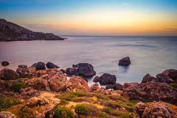 beautiful sunset and seascape view of Golden Bay in Ghajn Tuffieha region, Malta, travel background
