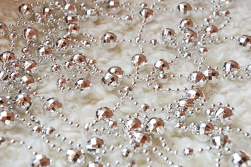 Gray beads for decoration, for decorating the Christmas tree and interior to meet a Happy Christmas and New year. White cozy plaid. Background for decoration of postcards for winter holidays.