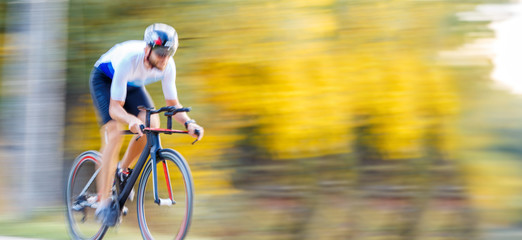 Fototapeta na wymiar Panning shot of sportsman riding a bike in park