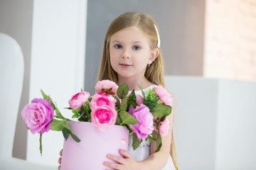 Obraz na płótnie Canvas Little girl carries a basket of flowers