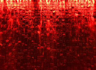 Waterfall with red light on a stone wall background.