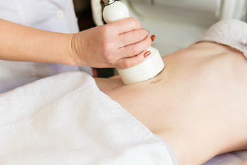 Body massage with cavitation. Young girl on massage table anti cellulite massage