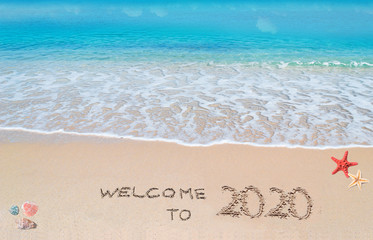 welcome to 2020 written on a tropical beach