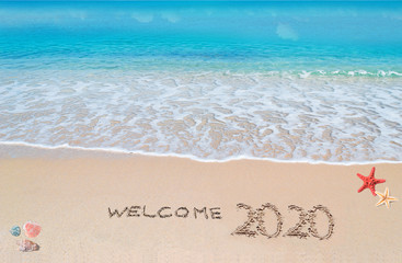 welcome 2020 written on a tropical beach