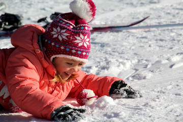 Fototapeta na wymiar La petite fille joue dans la neige 