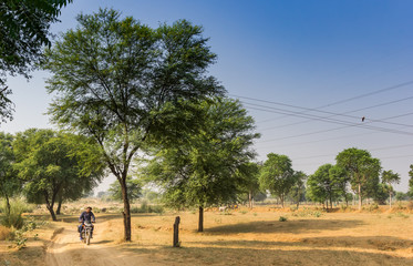 Fototapeta premium Motorcycle on a dirt road in rural Rajasthan, India