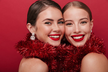 Pretty young positive two women wearing christmas accessories.