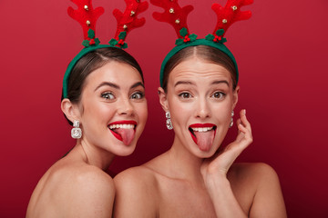 Optimistic young women wearing christmas accessories