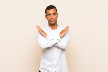 Young handsome brunette man over isolated background making NO gesture