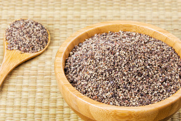 Bowl full of ground black pepper on a bamboo background