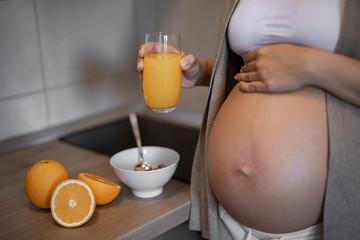 Pregnant woman is drinking orange juice