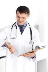 Doctor man using clipboard for filling up medication history records. Perfect medical service in clinic. Physician at work in hospital. Medicine and healthcare concepts