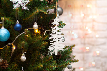 Beautiful green Christmas tree decorated with balls, big white tree and garlands. Close-up photo. Sparkling background