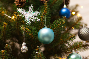 Beautiful green Christmas tree decorated with balls and garlands. Close-up photo