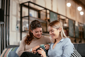 Best friends. Two beautiful woman sitting on sofa. Sisters at home