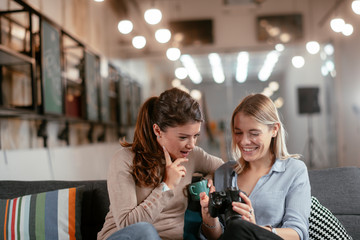 Best friends. Two beautiful woman sitting on sofa. Sisters at home