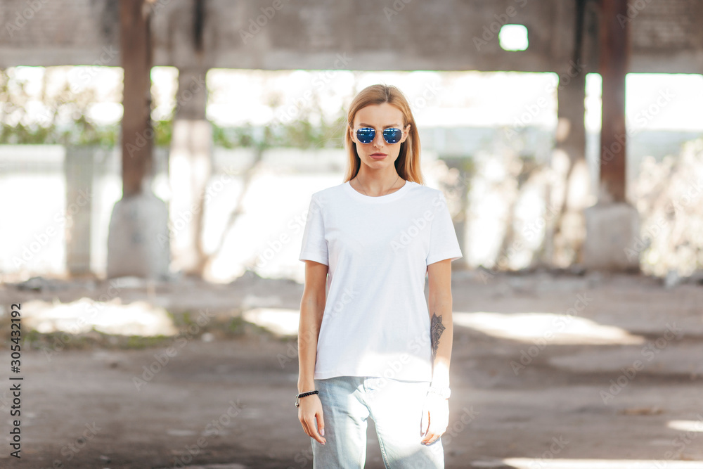 Poster Girl wearing t-shirt, glasses  posing against street , urban clothing style. Street 