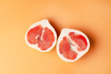 Fresh grapefruit on an orange background, close-up. Sex concept. The concept of women's health