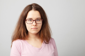 Fototapeta premium Head and shoulder portrait of brunette young woman with glasses