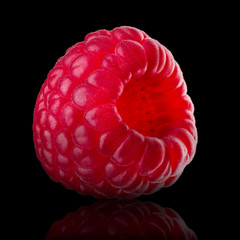 Macro photo of raspberry with reflection isolated on black background