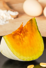 Slice of pumpkin just cut on black dish