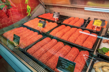 Raw minced meat in a butcher shop, chilled meat products on the counter
