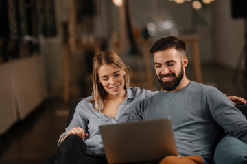 Young happy couple. Partners using laptop tohether. 