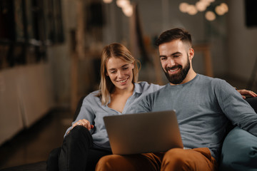 Young happy couple. Partners using laptop tohether. 