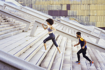 latin woman and black sports man running up stairs