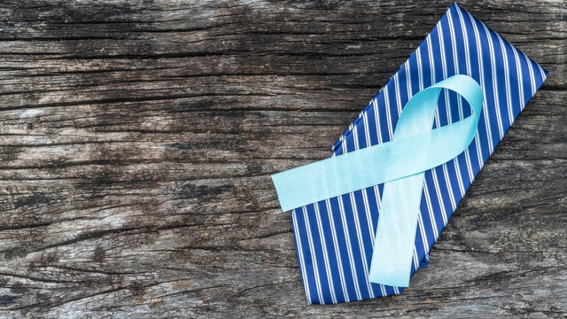 Blue awareness ribbon for prostate cancer, men health in November with light blue bow color on medical doctor record, male patient healthcare concept - Powered by Adobe