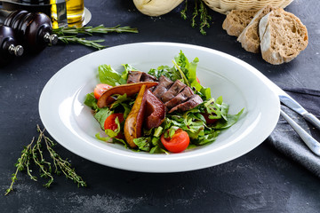 Baked and fried duck breast with fruit garnish. Sliced sweet pear