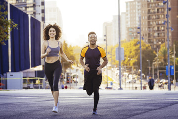 latin woman and black man jogging in the city