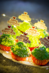 Christmas baking. Green Christmas cupcakes with the inscription Merry Christmas. Sweets for the Christmas table. Christmas sweets close-up.