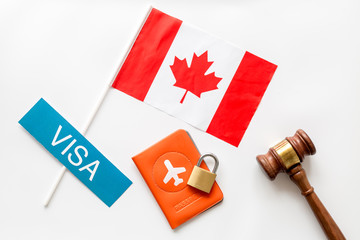 Visa to Canada concept. Canadian flag near passport and judge hammer on white background top view