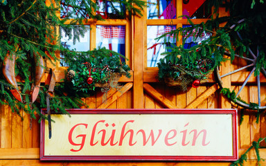 Fototapeta na wymiar Hot Gluhwein name plate on Christmas Market at Gendarmenmarkt square in Winter Berlin, Germany. Advent Fair Decoration and Stalls with Crafts Items on Bazaar. German street Xmas and holiday