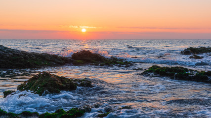 Colorful sunrise on a rocky seashore