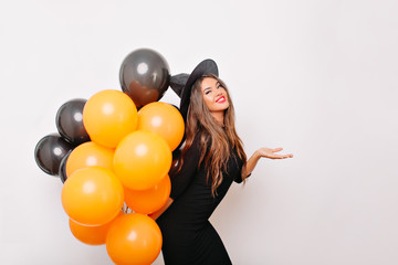 Excited shapely woman waiting for halloween party. Indoor portrait of enthusiastic brunette girl...