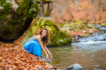 woman in blue dress near a river in autumn day
