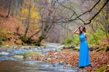 woman in blue dress near a river in autumn day