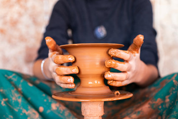 Hands of a potter on the pottery wheel 