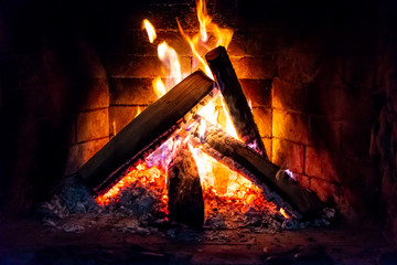 Flames in the fireplace. Burning wood. Brick fireplace.
