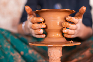 Fototapeta na wymiar Hands of a potter on the pottery wheel 