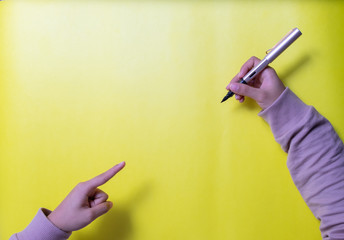 persona escribiendo sobre lienzo amarillo con pluma o bolígrafo