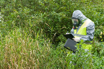 employee in a suit with protection against contaminated environment records studies of the area for...