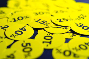 Yellow round stickers with discounts of 10 to 50 percent. Sell-out. Discounts on a black background. Black Friday. Price fall. Posters. Macro discounts.