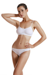 Fototapeta premium Young woman in white underwear, with bundled hair, posing in studio, isolated on white. Plastic surgery, aesthetic cosmetology. Close-up.