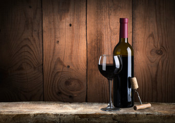 red wine bottle and wine glass on wodden barrel